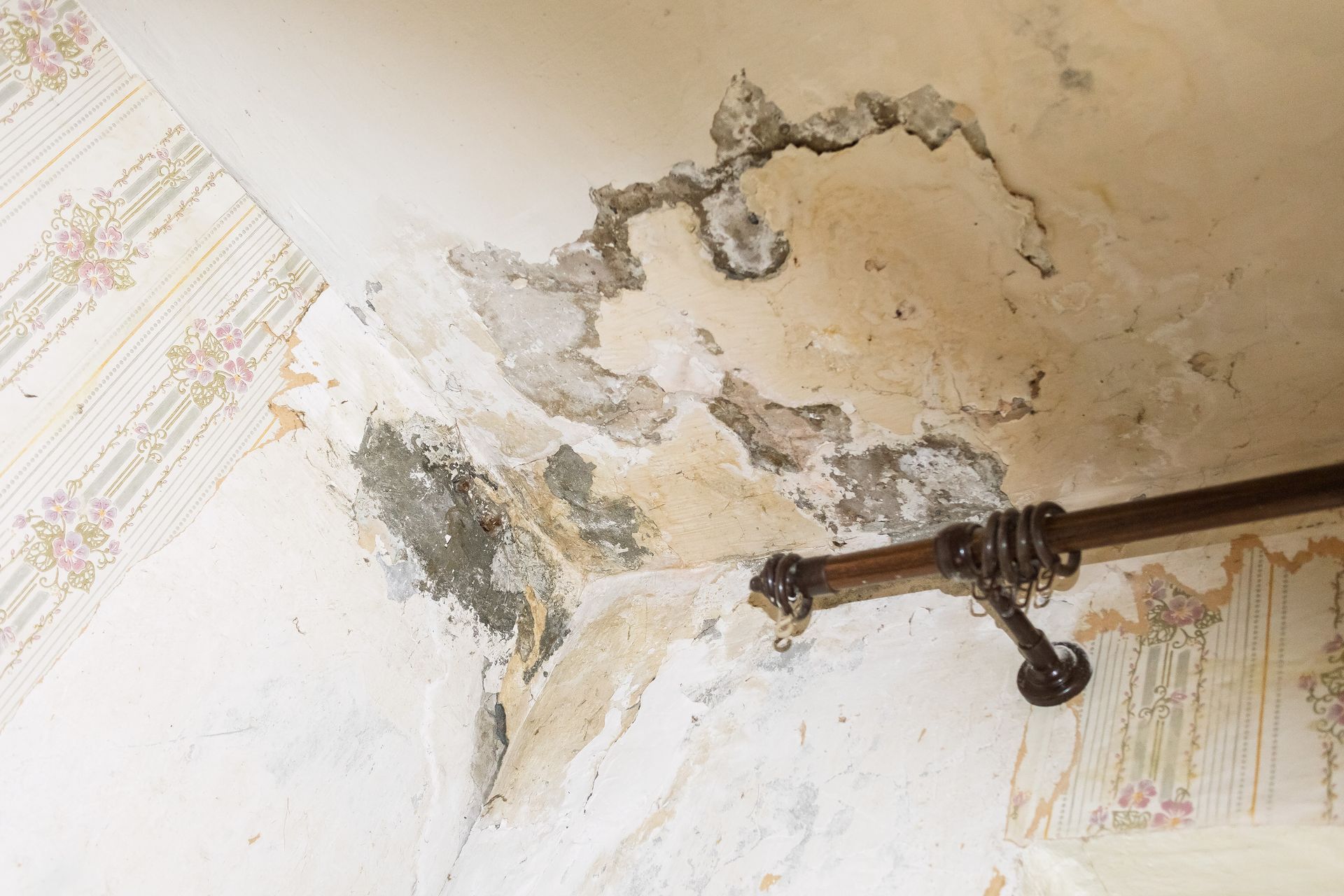 Damaged wall with water stains and mold in a room.