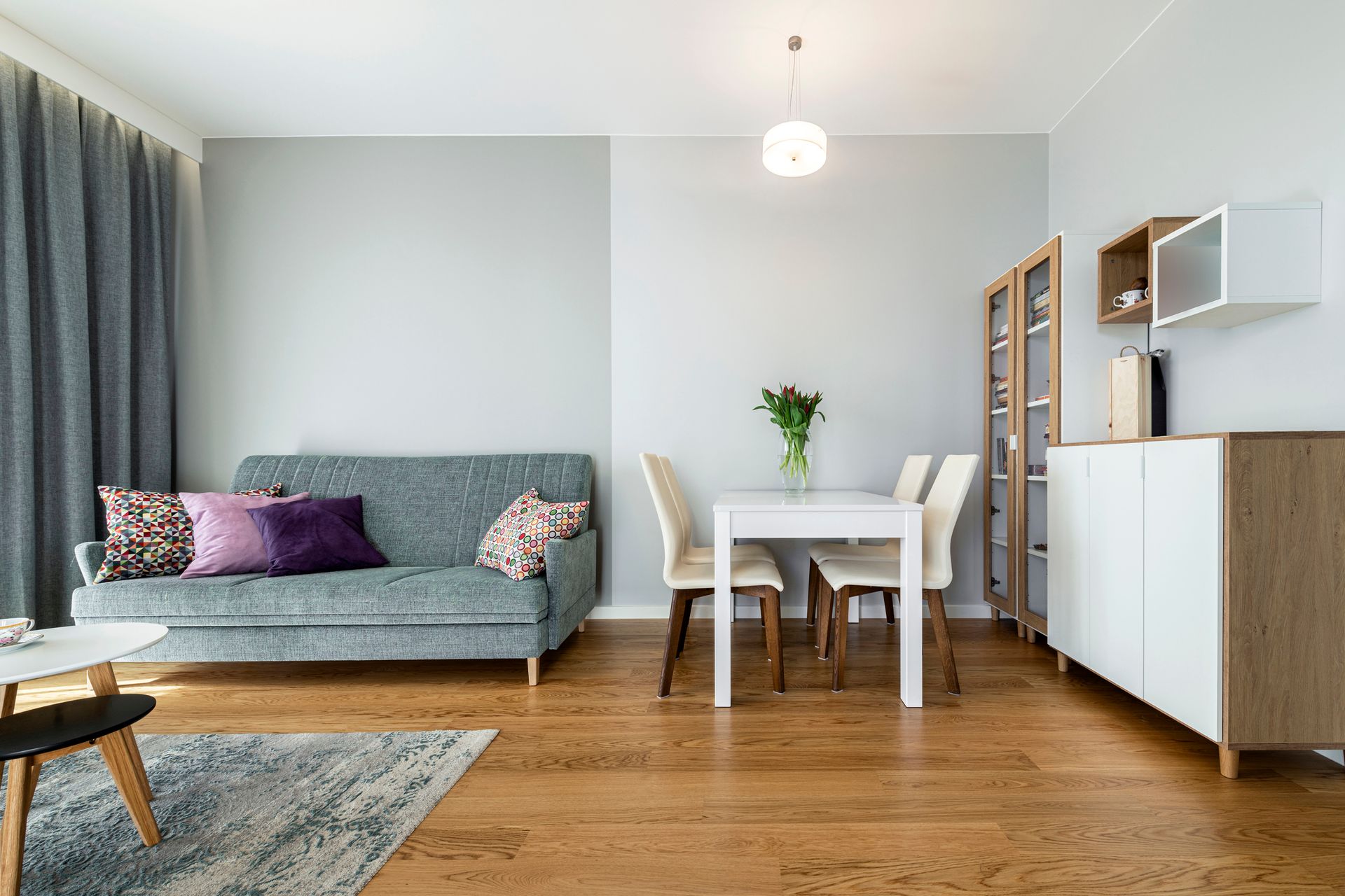 A living room with a couch , table and chairs.