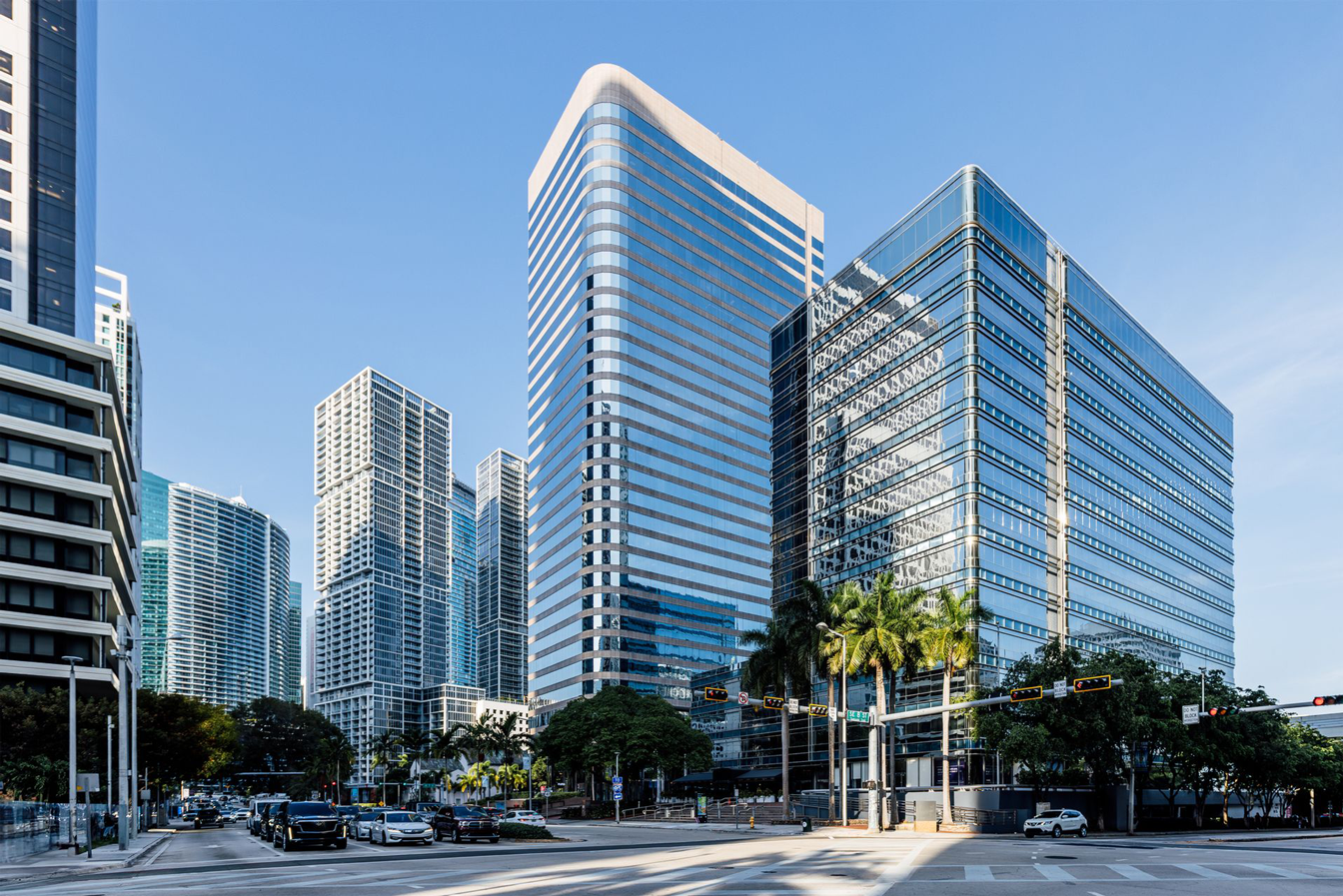 A city street with a lot of tall buildings and cars driving down it.