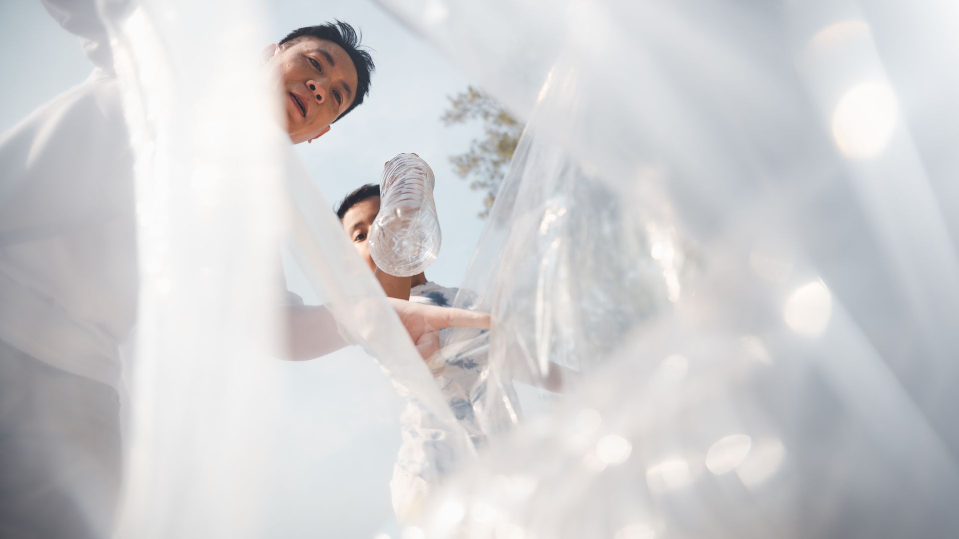 People looking in a trash can