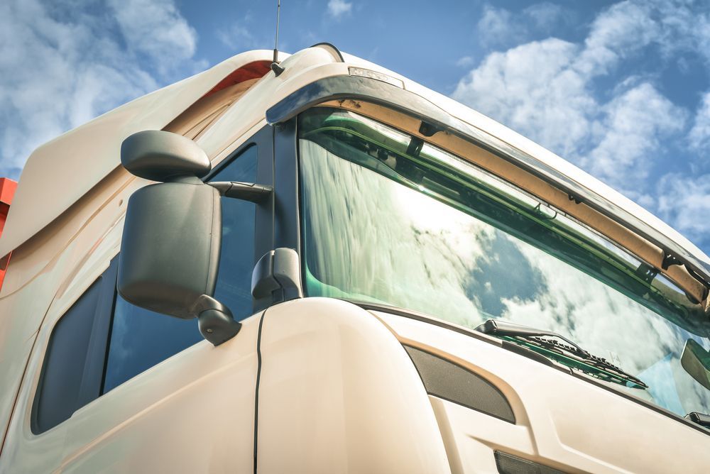 Close-Up of a White Semi-truck Cab Against a Blue Sky With Clouds — Mission Truck Training in Mountain Creek, QLD