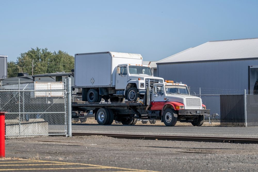 A Flatbed Truck Transporting Two Older — Mission Truck Training in Mountain Creek, QLD