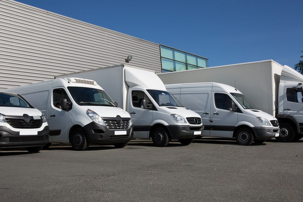 White Delivery Vans Parked in Front of a Building on a Sunny Day — Mission Truck Training in Noosa, QLD
