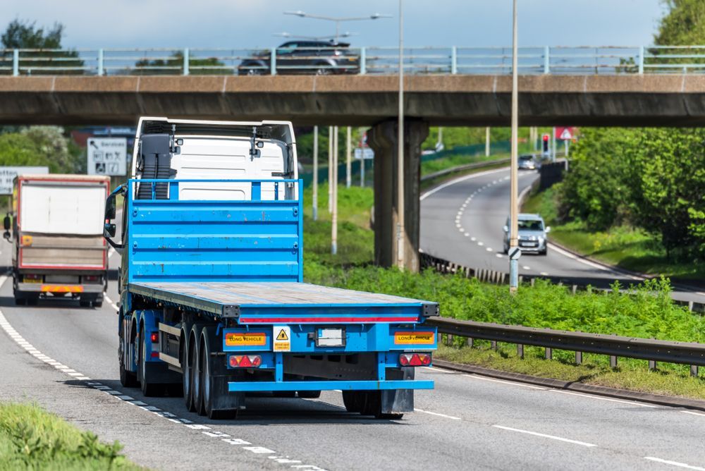 A Blue Flatbed Semi-truck Driving on a Highway — Mission Truck Training in Mountain Creek, QLD