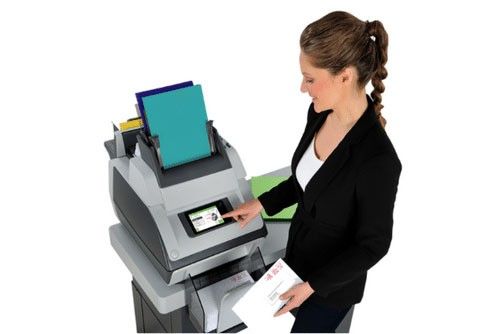 A woman is using a printer to print an envelope.