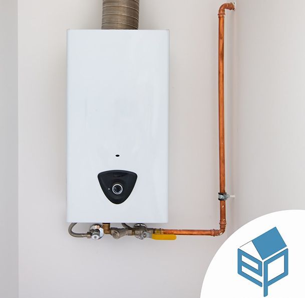 Uno scaldabagno a gas bianco a parete con tubo di sfiato argentato e tubature in rame a vista, su uno sfondo neutro.