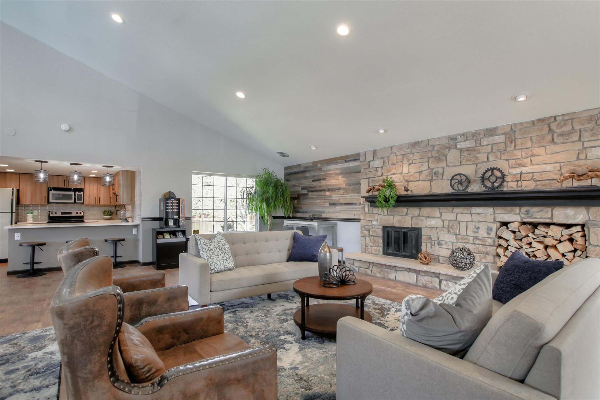 Clubhouse with stone fireplace, couches, and open kitchen.