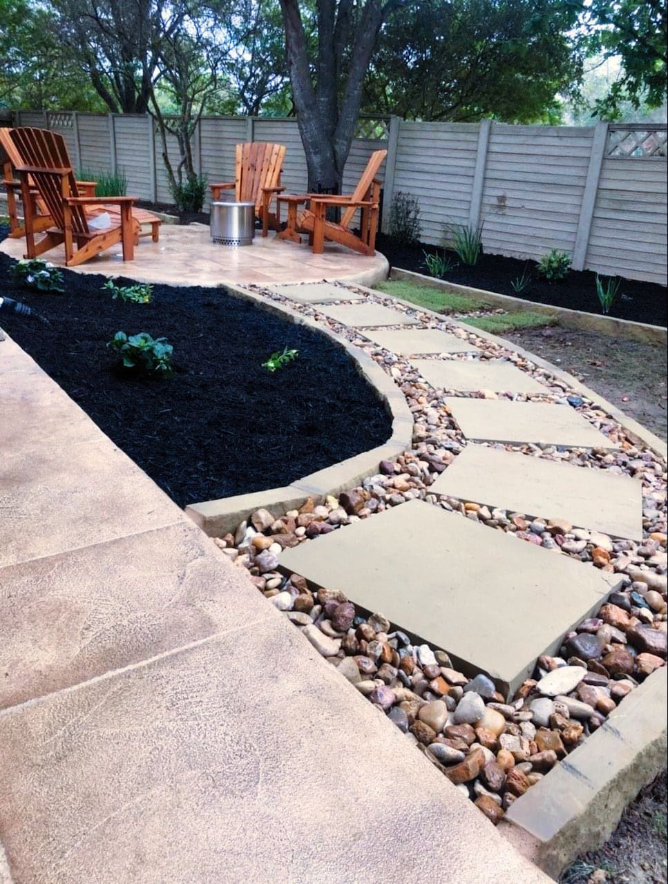 A patio with wooden chairs and a stone walkway