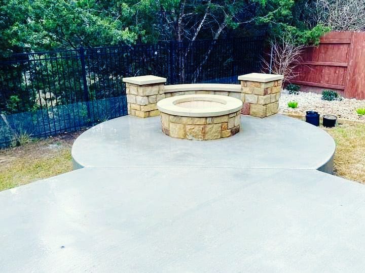 A fire pit is sitting on top of a concrete patio.