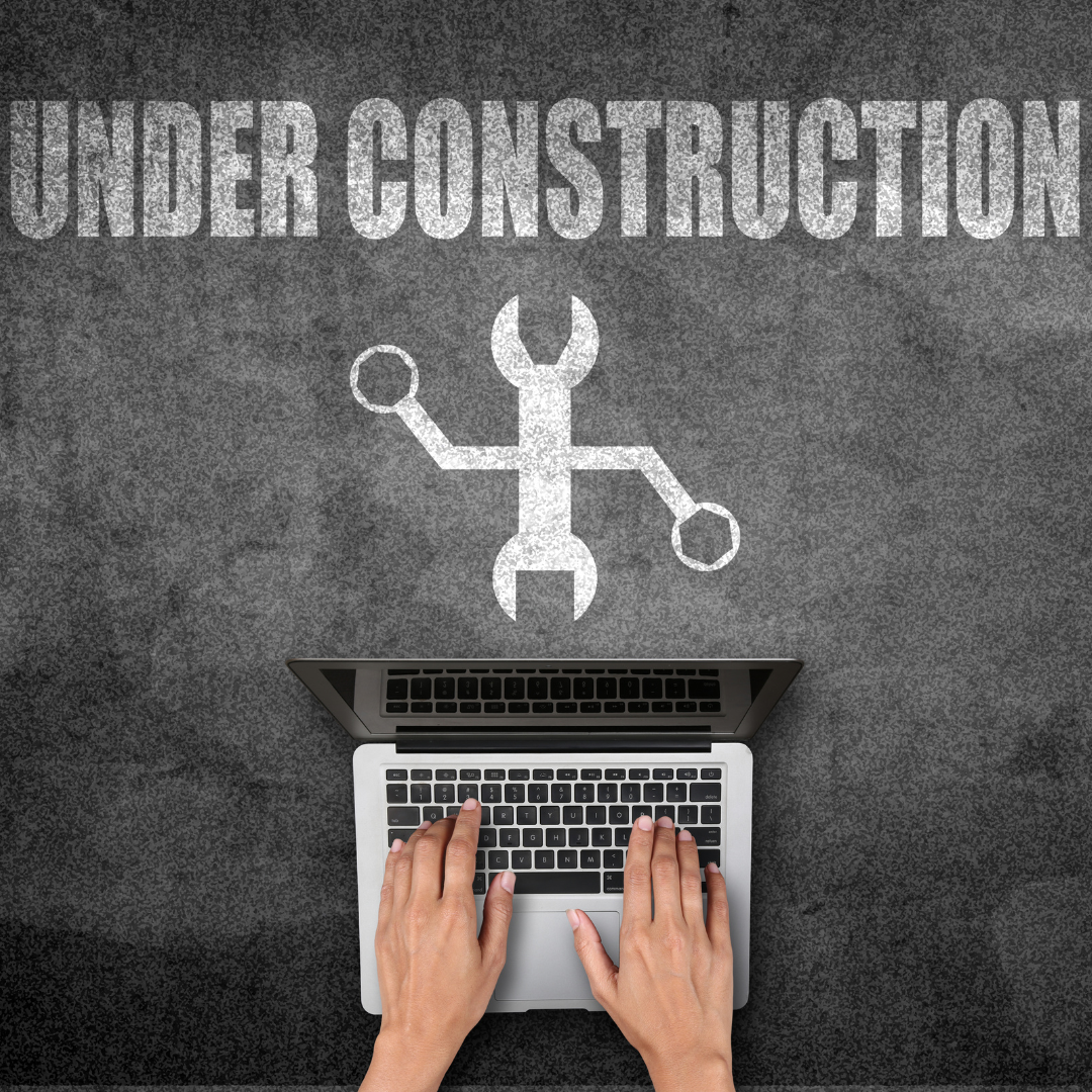 Graphic of an open laptop with hands typing on it, overlaid with a chalk-like drawing of a wrench and a screwdriver forming an 'X,' under the phrase 'UNDER CONSTRUCTION' in large, block letters, suggesting website development or maintenance.