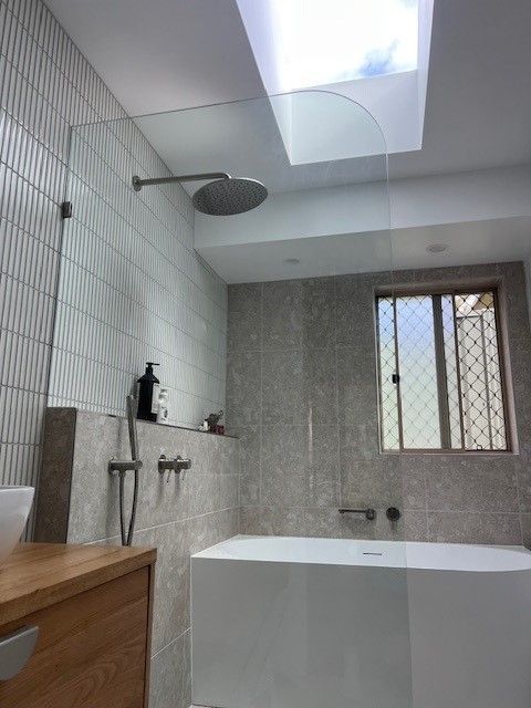 Empty glass storefront display in a modern indoor corridor with black framing and white walls