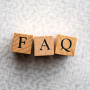Three wooden blocks displaying the letters F, A, and Q, arranged horizontally against a blurred, white maze background.