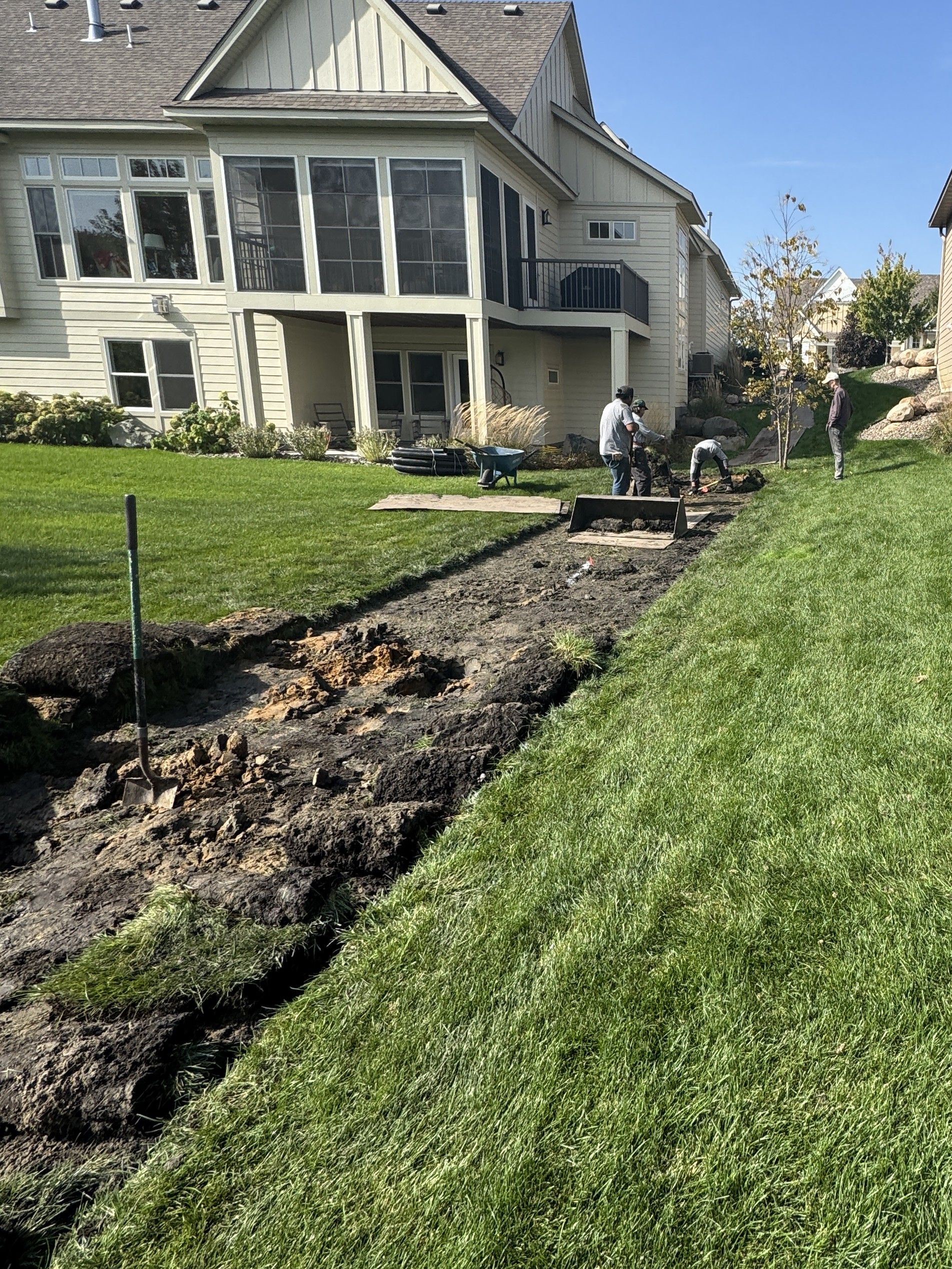 Our crew removing sod where a new French drain is to be installed in a backyard 