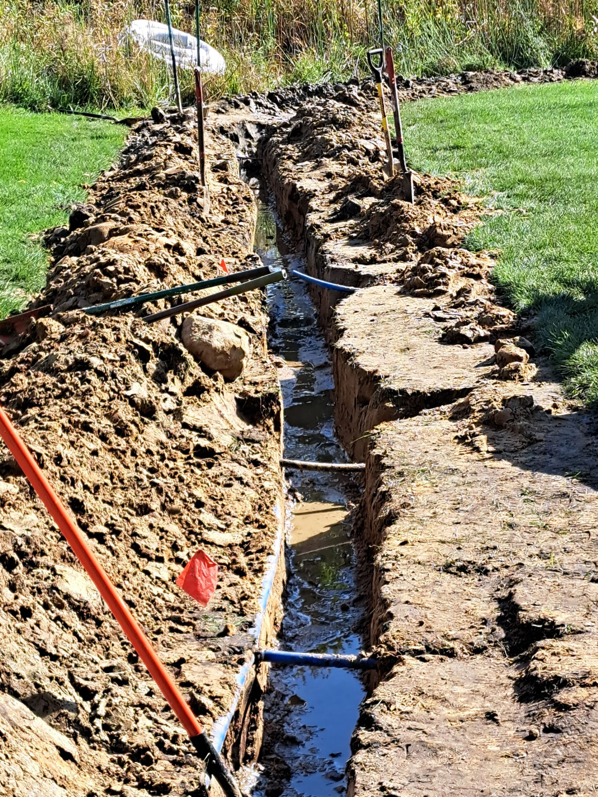 how KG Landscape protects lawns with boards and by cutting out then reusing sod during drainage work