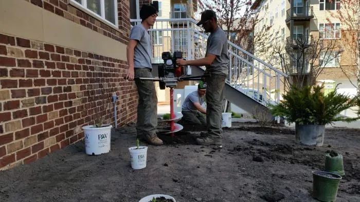 Using a dirt soil auger to dig holes for landscaping planting KG Landscape Minneapolis MN 