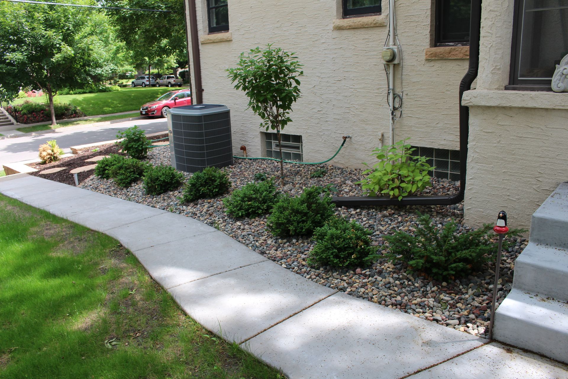 After photo showing landscaping around house foundation with rock and plants one year after installation in Minneapolis