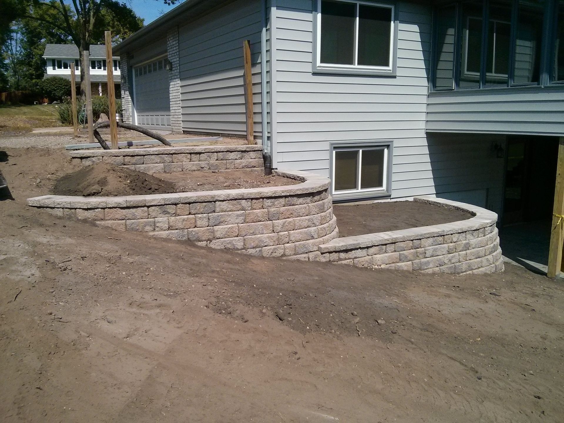 multi-level retaining wall being built onto side yard