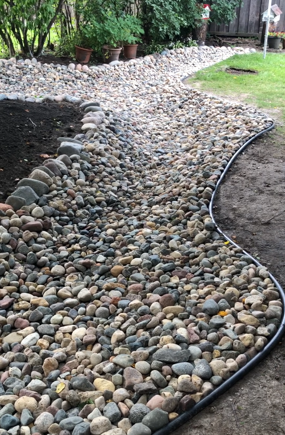 Backyard dry creek bed with drain tile below feeding into front yard dry well