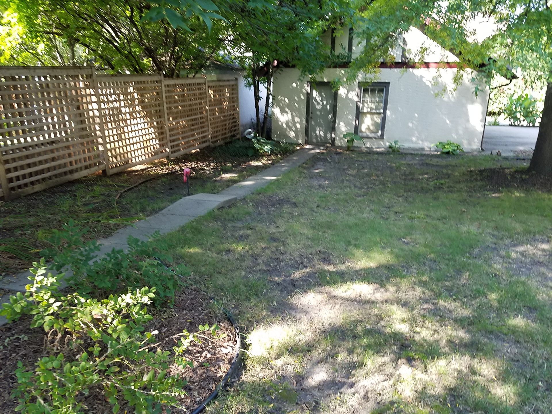Before photo of old narrow sidewalk between garage and house in Minneapolis that needs regrading