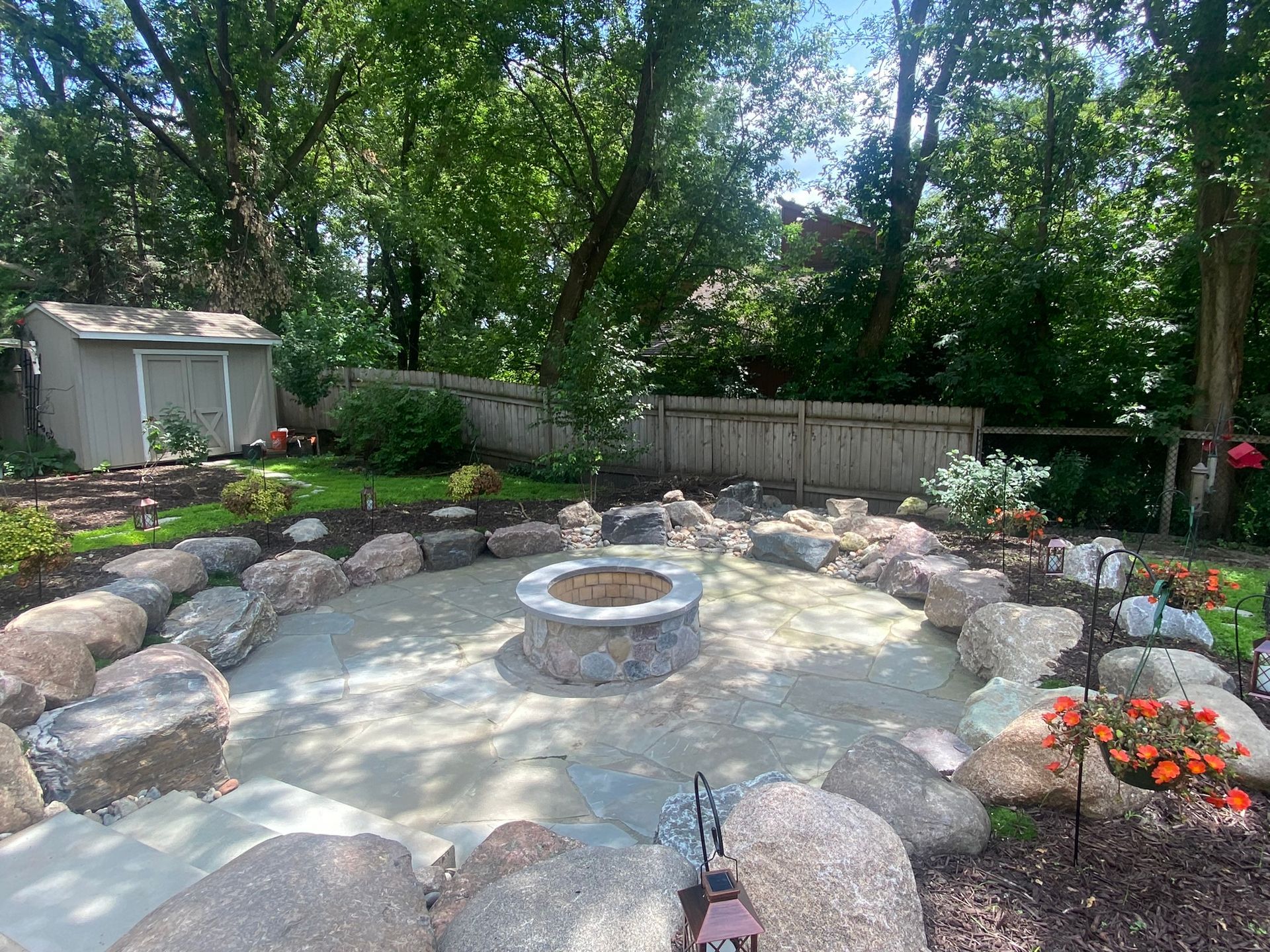 Bluestone+patio+with+raised+built+in+fir+pit+boulder+sitting+wall+Plymouth+MN+KG+Landscape+design+contractor