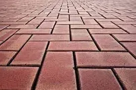 A close up of a brick pavement with a herringbone pattern.