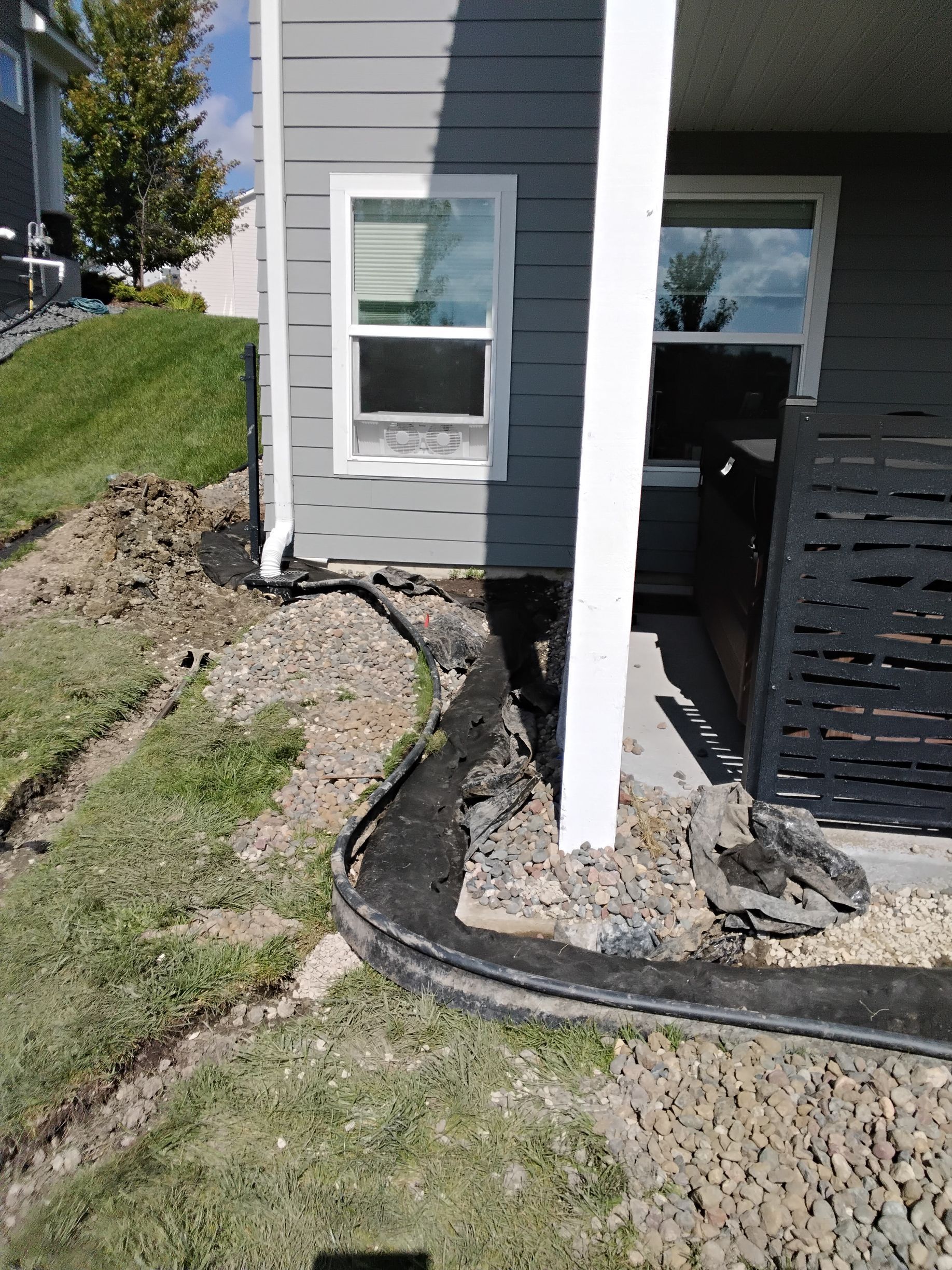 French drains being installed around a homes foundation and the patio in Plymouth MN by KG Landscape  