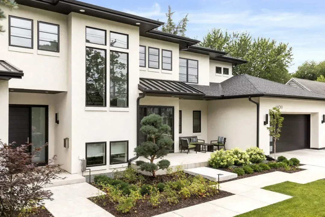 A large white house with a lot of windows and a walkway in front of it.