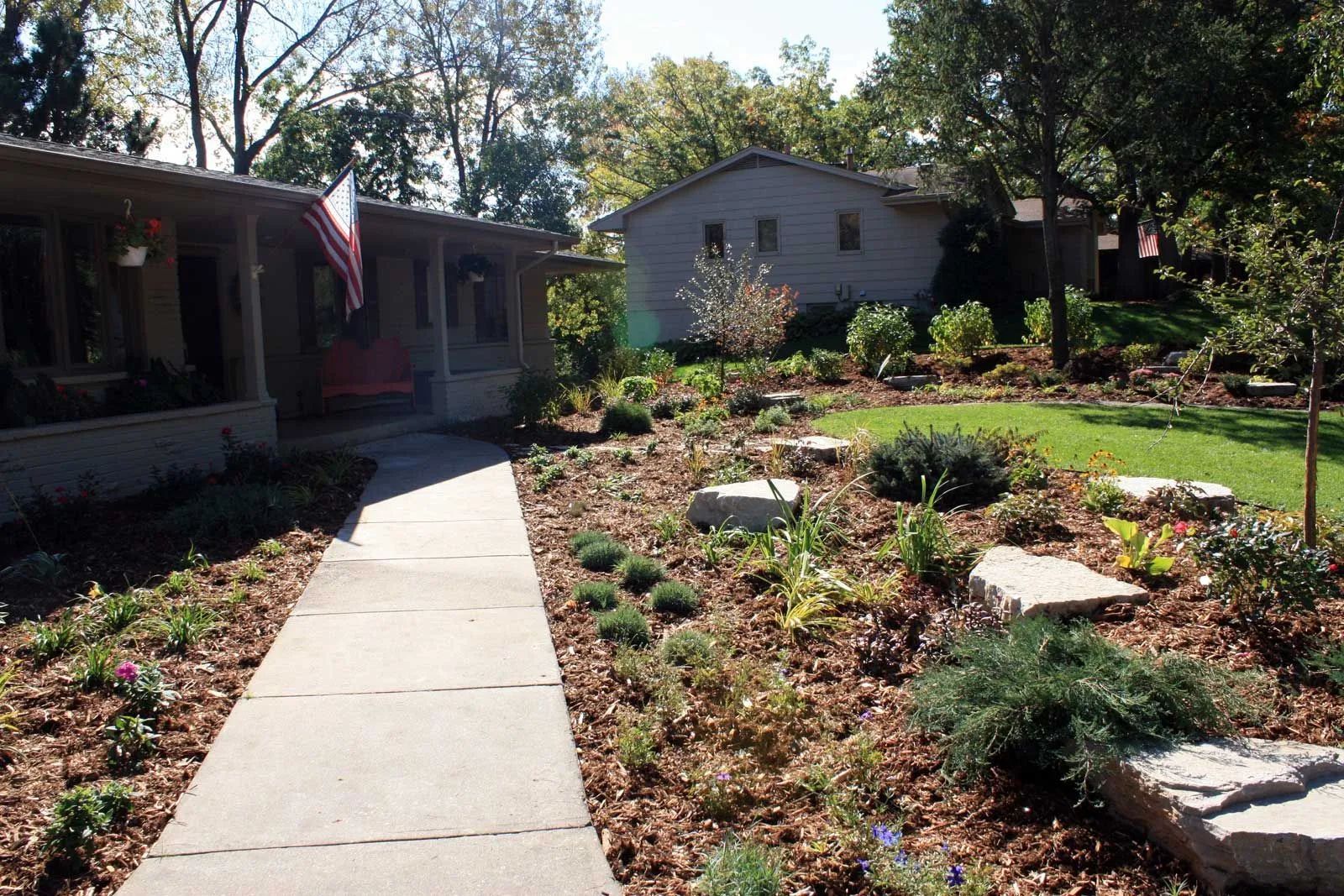 Front yard landscaping idea with larger beds boulder outcroppings landscaping with gray white limestone front yard in Edina Minnesota KG Landscape.com