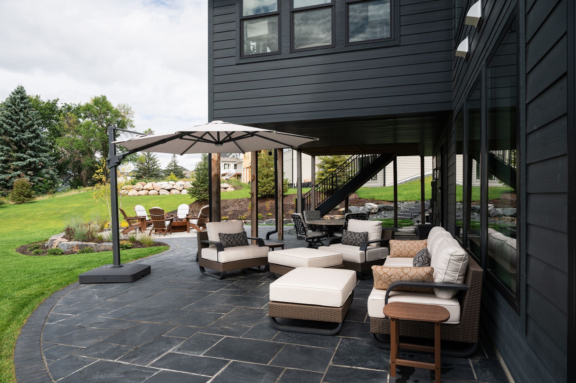Backyard patio for walkout basement in Plymouth with Black pavers and nicer furniture 