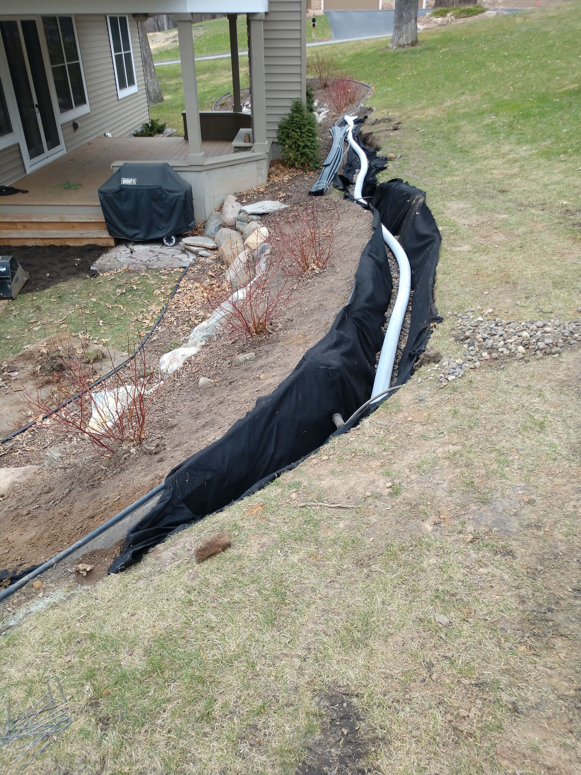 Our crew liner the new French drain trench with filtration fabric and installing the 4