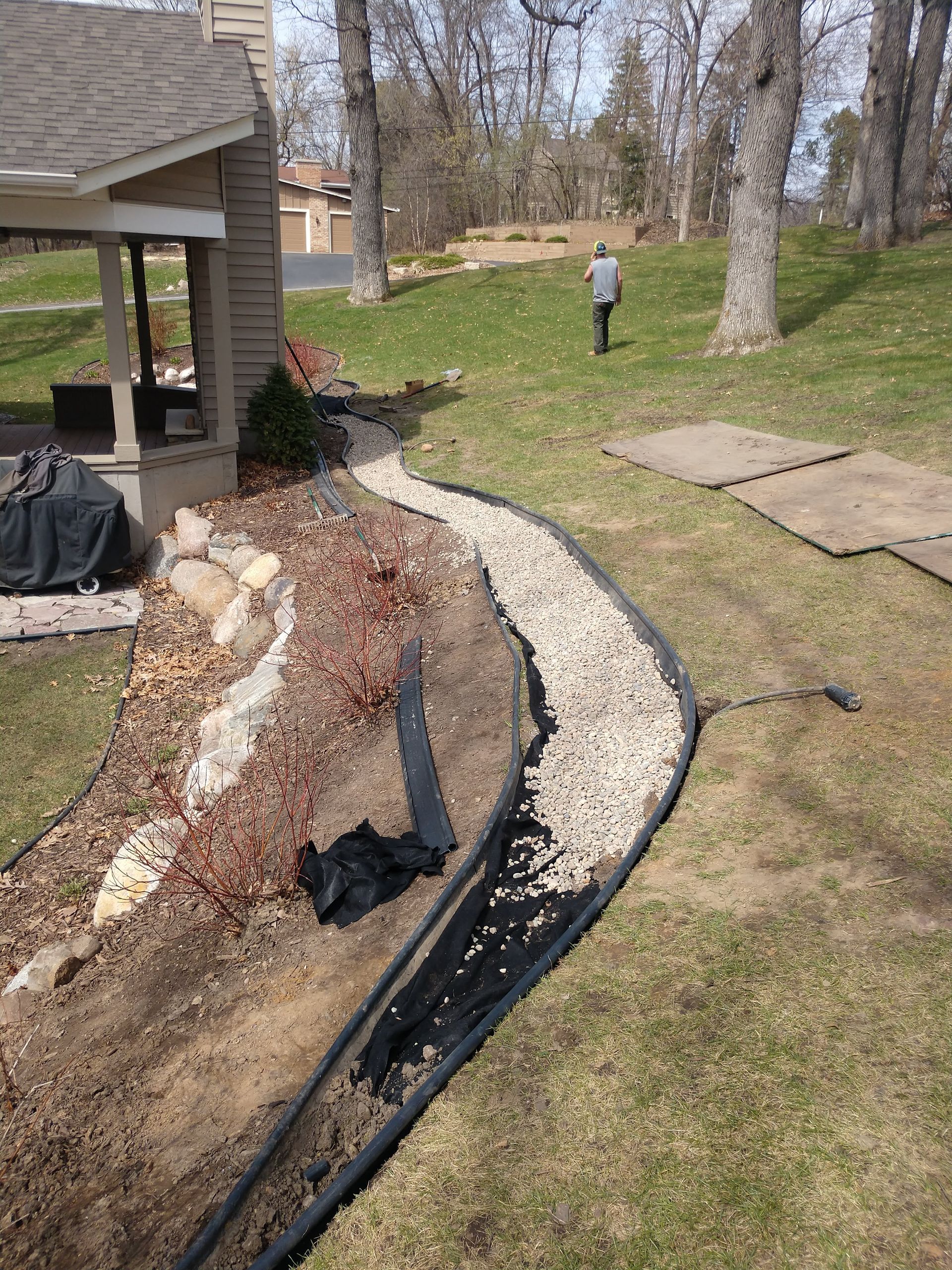 Our crew starting to cover the French drain with rive rock