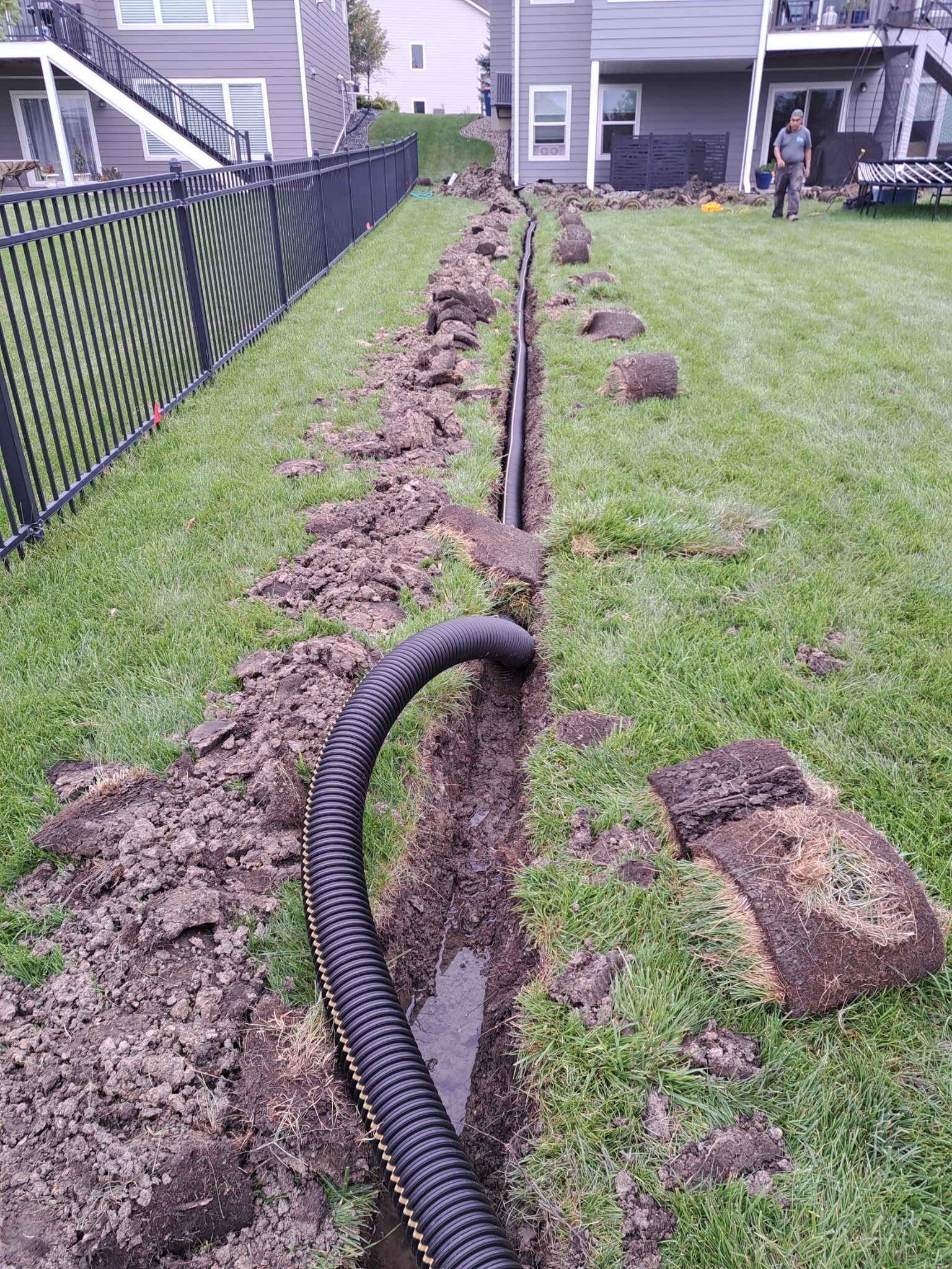 underground drain pipe running to far back corner of yard where water can discharge via a pop-up emitter 