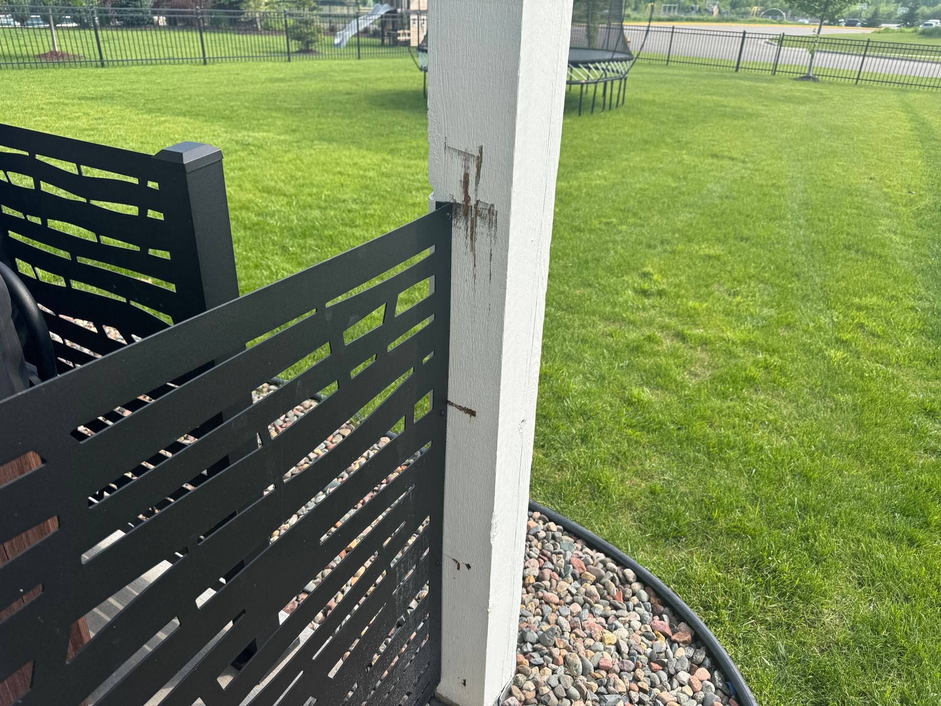 heaving patio lifts due to frost heave from wet soils in Plymouth shows marks where fence scraped post 