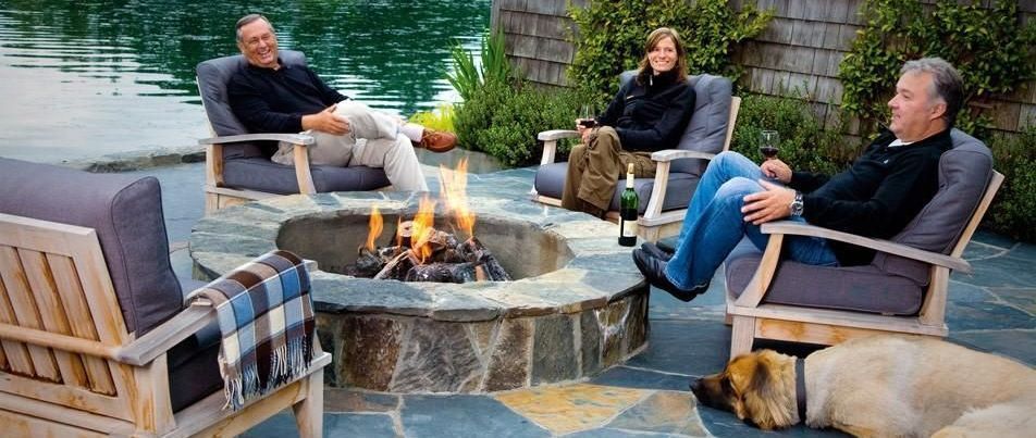 A group of people are sitting around a fire pit.