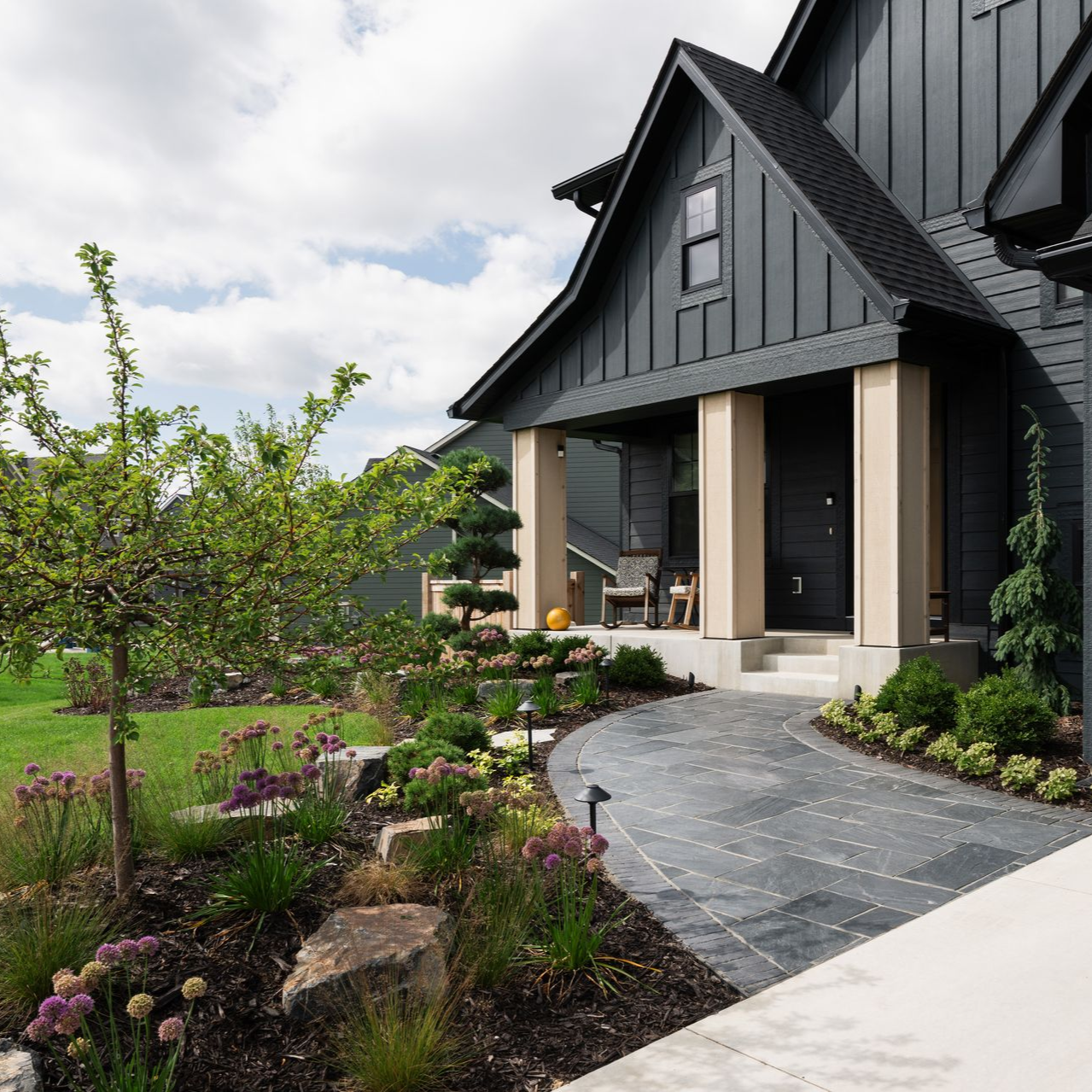 Landscape design plan with trees, shrubs, and building layout. Green, white, pink and gray colors.