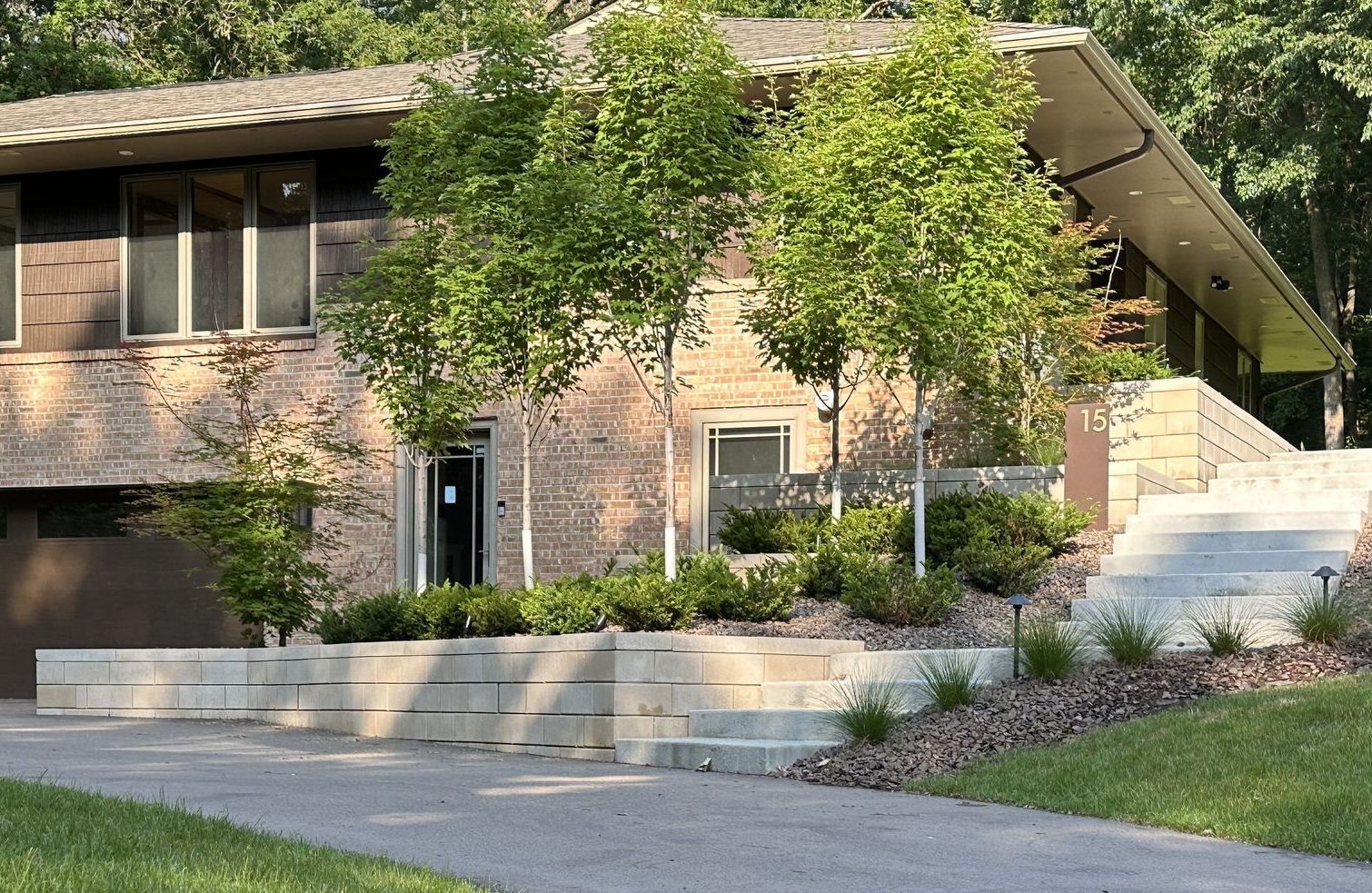 Mid century modern landscaping with angled retaining walls and steps in front yard 
