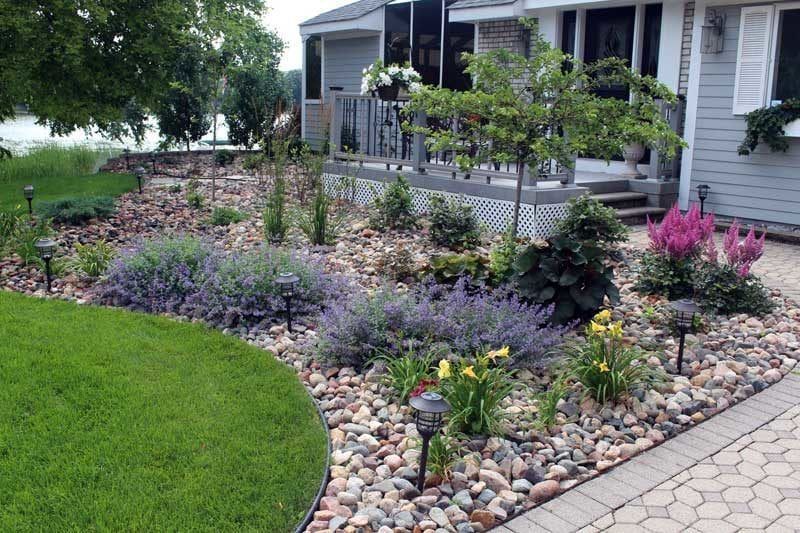 beautiful landscaping idea example with low maintenance river rock plant bed curved edging shape to soften deck in front of the house tina crab focal point tree catmint KG Landscape Minneapolis MN  