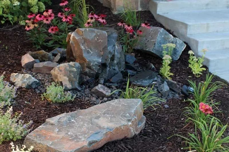 Front yard boulder outcropping landscaping with pond less water feature bubbling rock with flowers colorful in Chanhassen MN  KG Landscape.com  