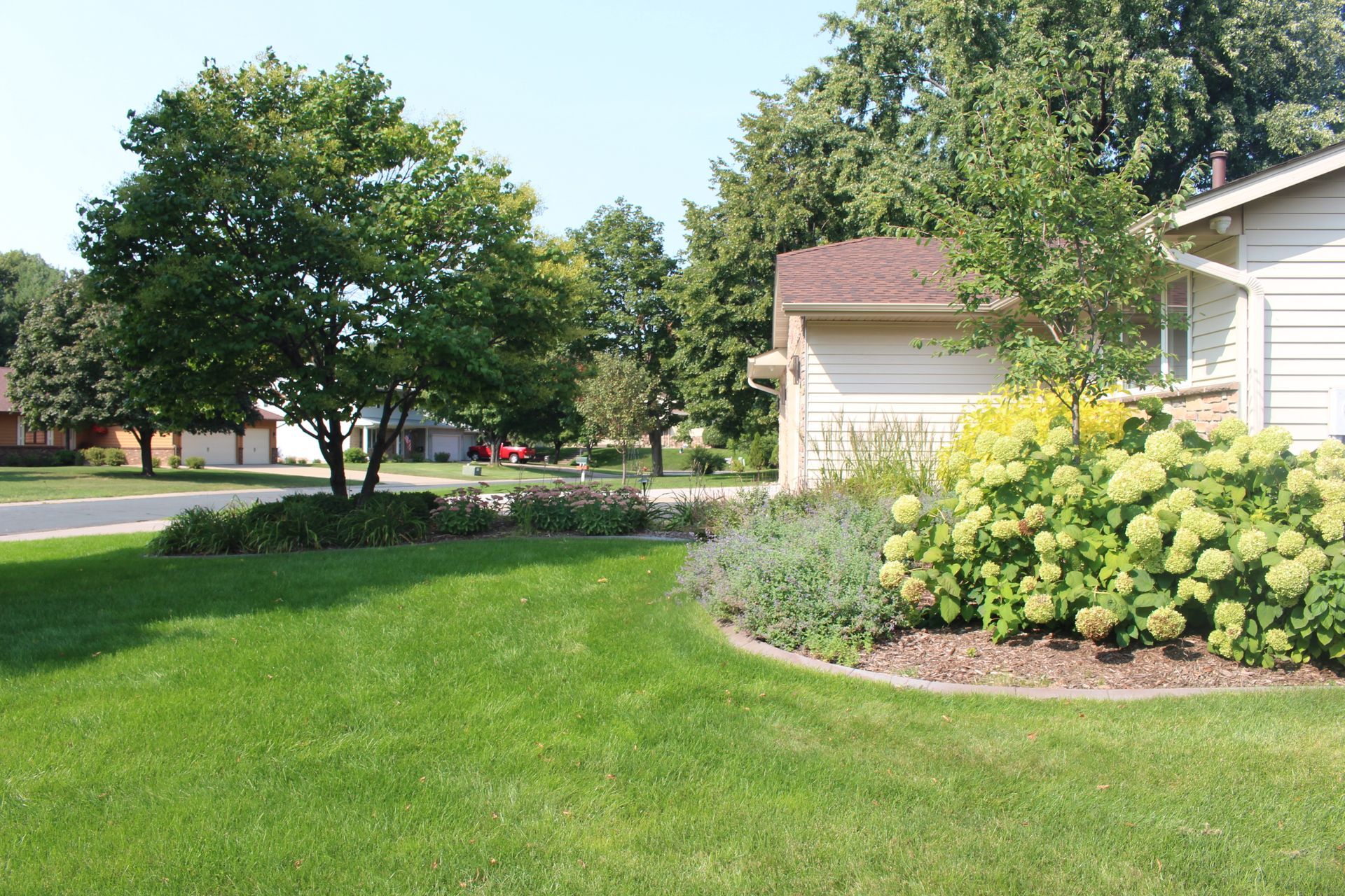 Front yard curb appeal landscaping with lilac tree garden glow dogwoods  grasses hydrangeas flowers North Oaks MN KG Landscape Design Contractor