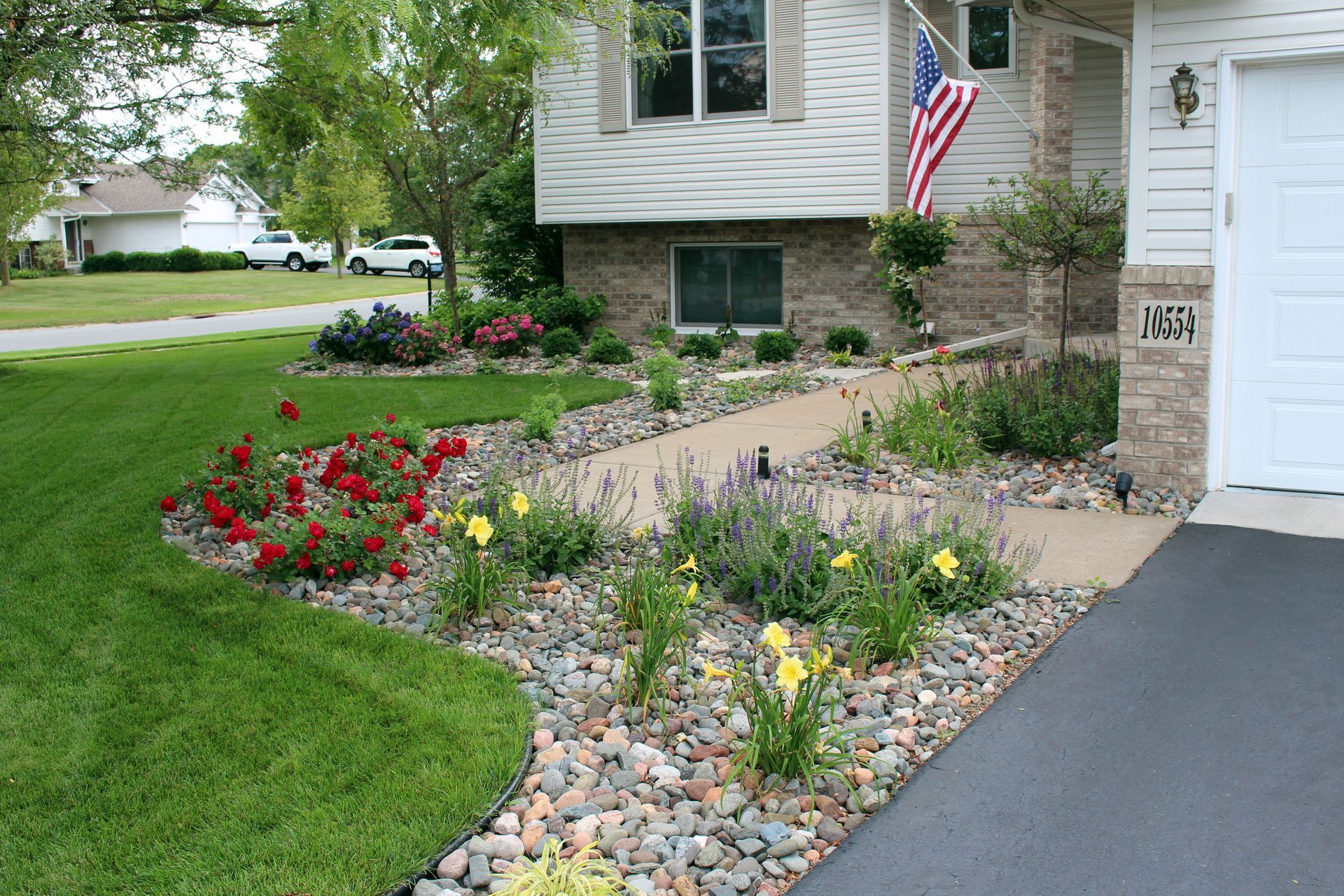 Beautiful colorful simple landscaping for front yard with garage in front of the house in Blaine MN KG Landscape Design Company roses daylilies catmint
