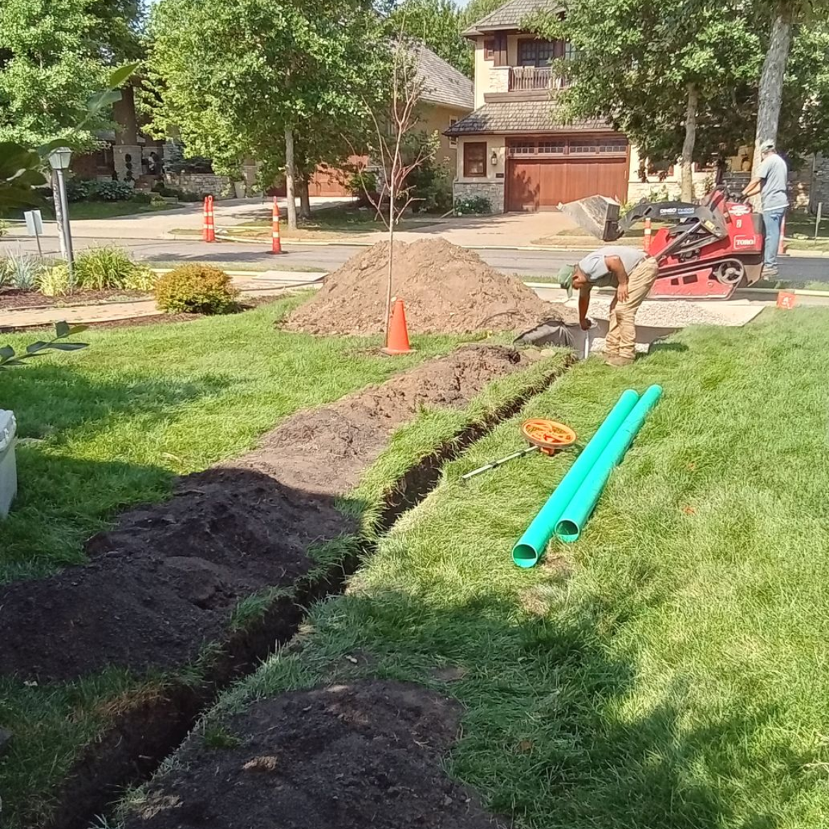 During: shows crew excavating a new dry well and measuring depth and starting to fill with rock
