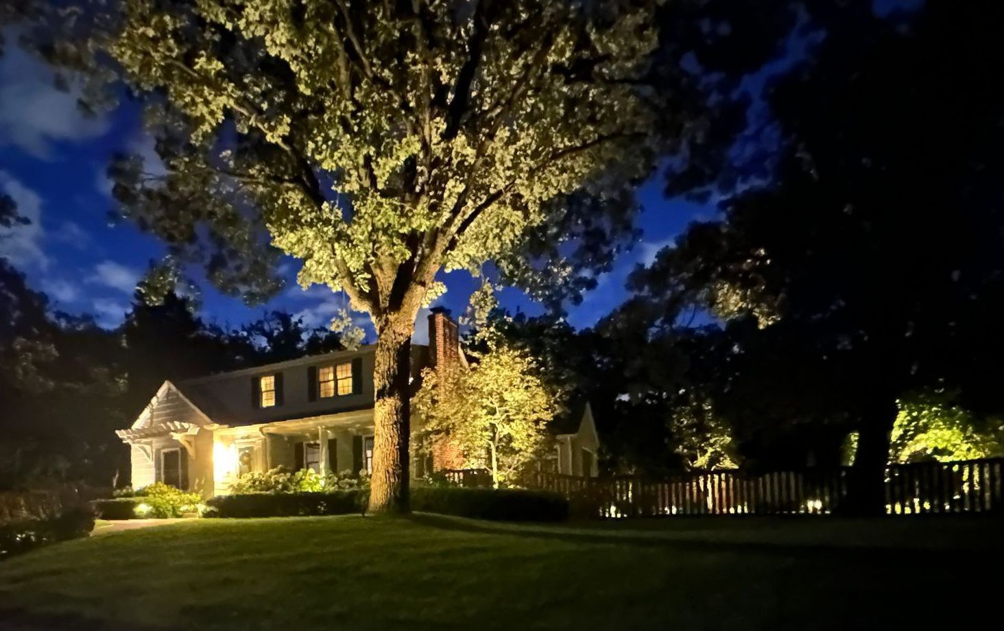 front yard landscape lighting ideas inspiration adds curb appeal and safety at night boxwoods hydrangeas oaks tree up light column and downlight walkway with pathway lights St. Louis Park MN KG Landscape 