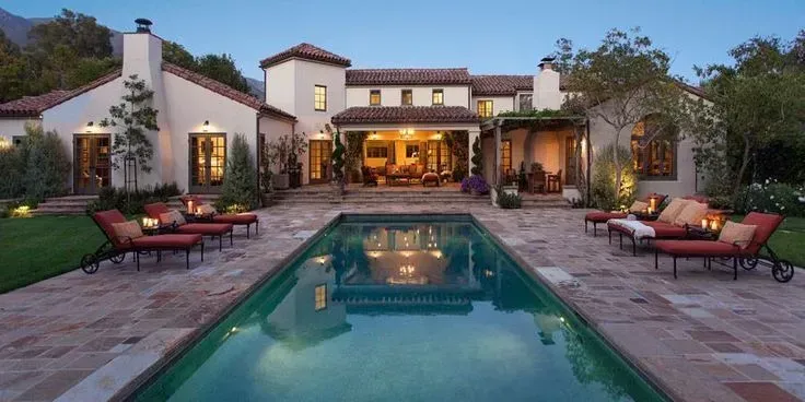 A large house with a large swimming pool in front of it