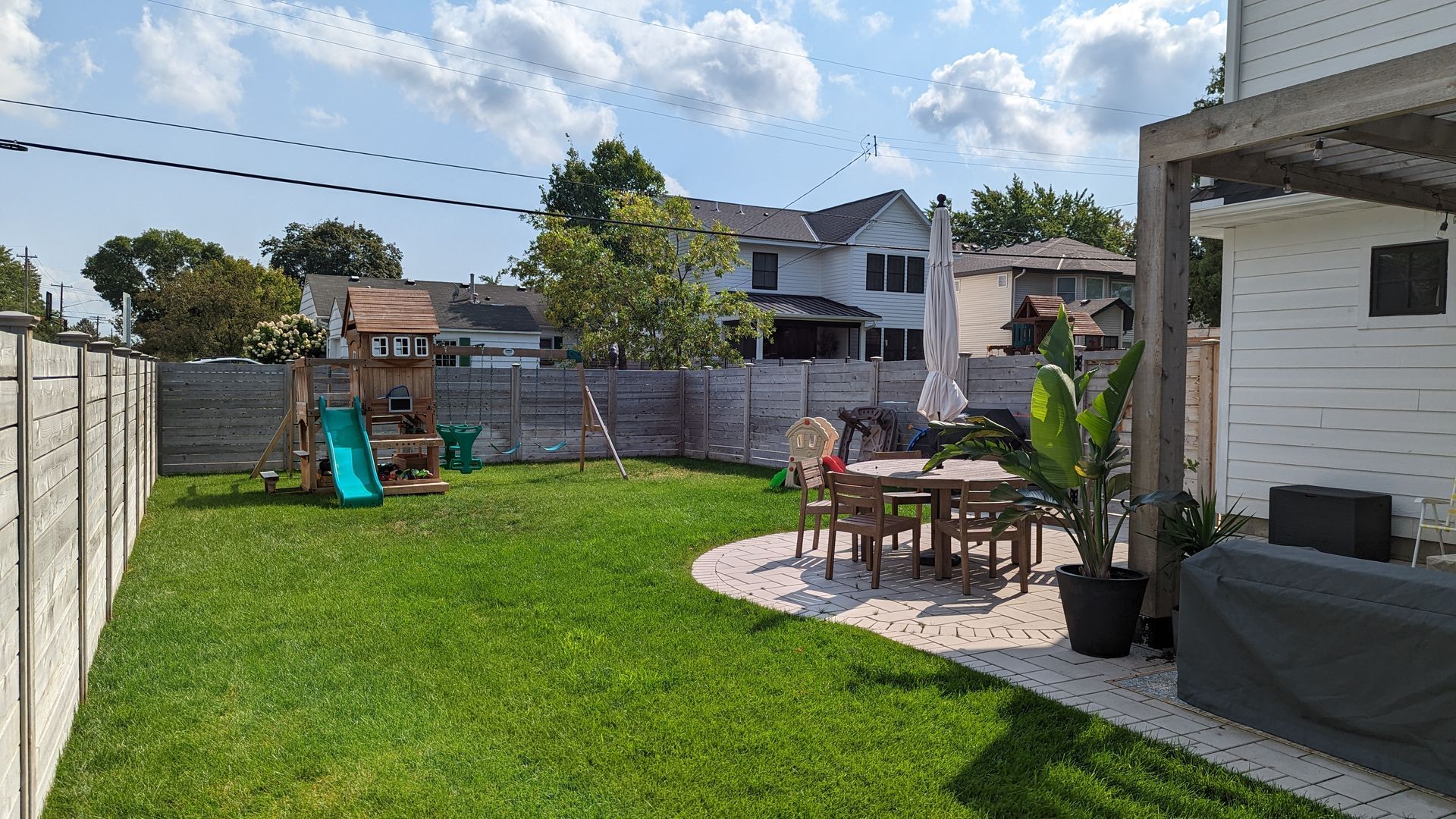 After photo of lawn in backyard of home next to patio.