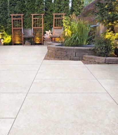 A patio with a bench and a fire pit in the background.