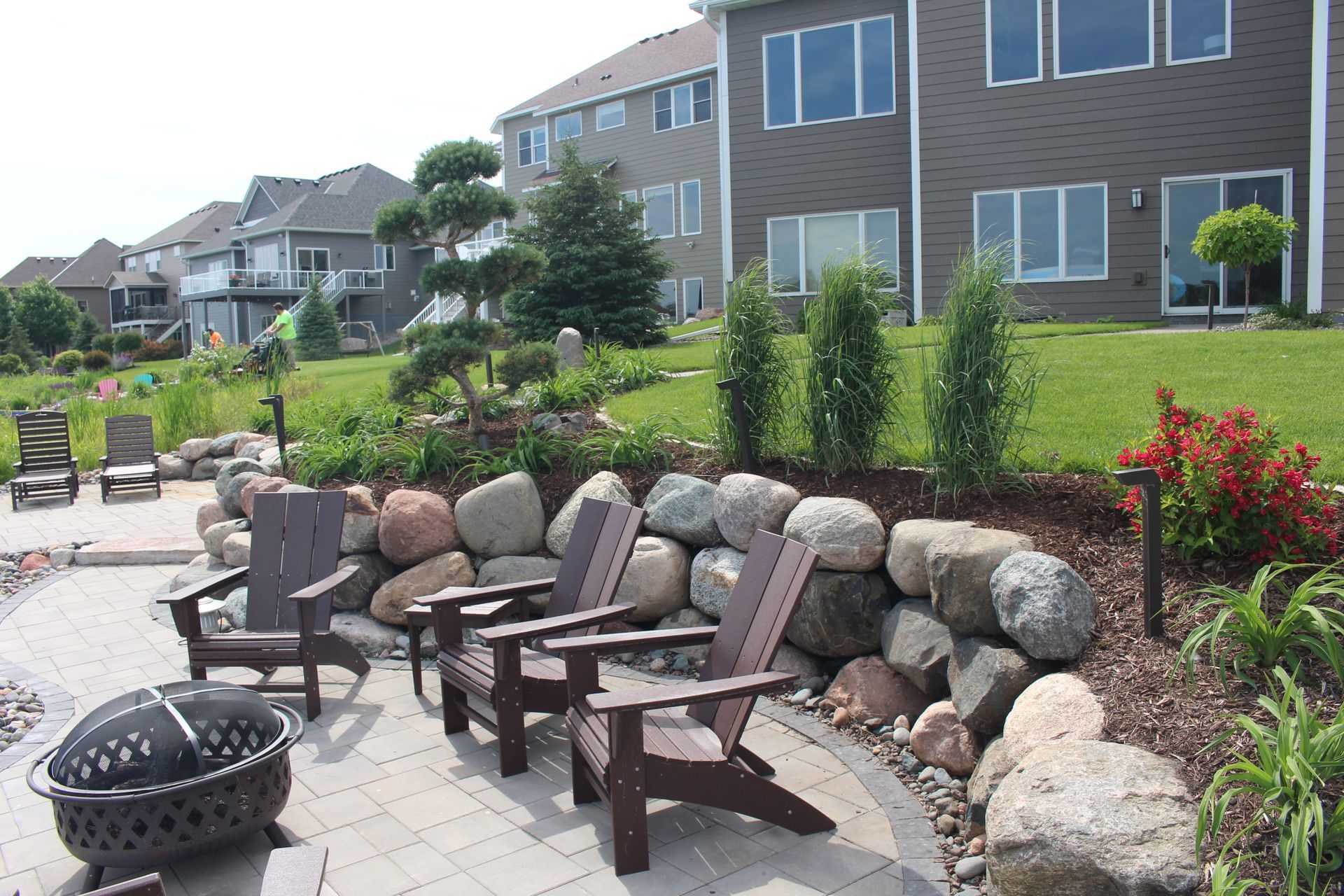 Lakeshore paver patio ideas carved into the hill with boulders plantings lighting Blaine MN KG Landscape  