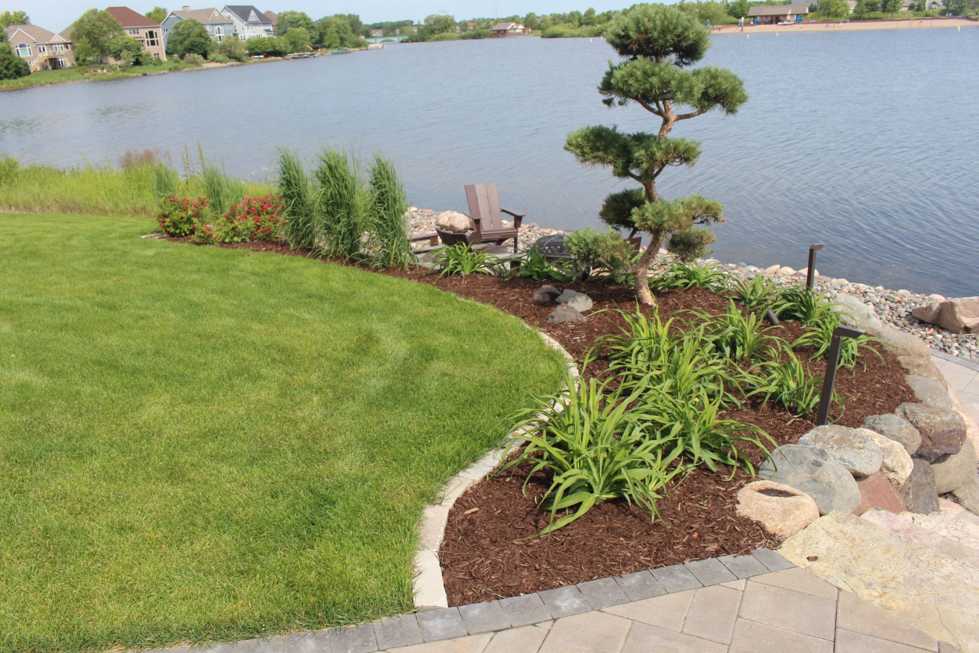 Paver patio ideas and walkway sitting area with fire pit by the water in Blaine MN KG Landscape 