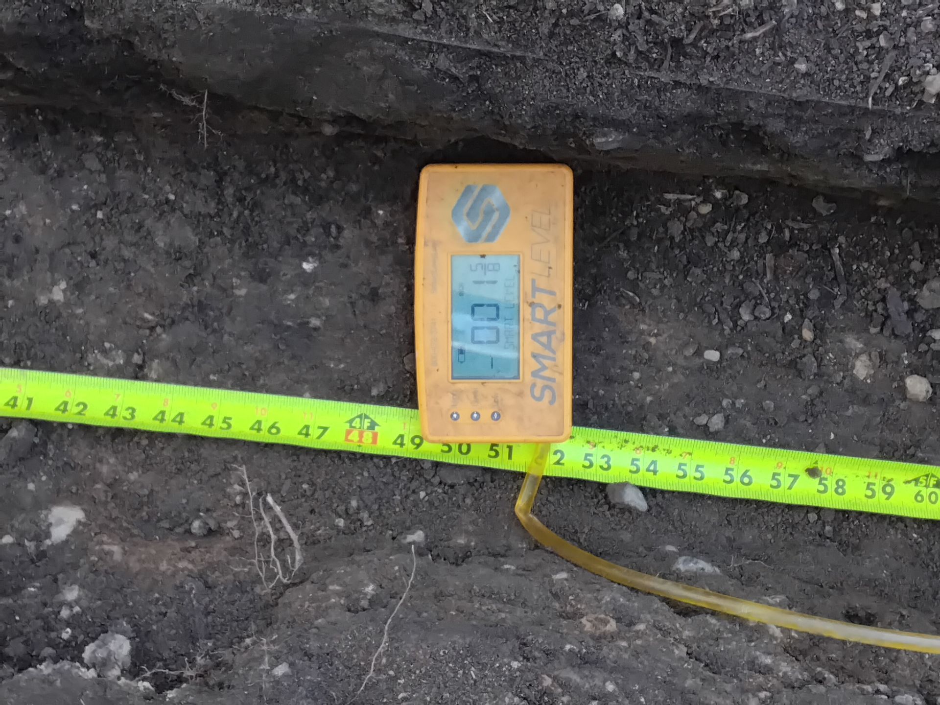 During picture crew uses altimeter to set precise slope in drainage trench prior to installting the pipe Minneapolis Drainage fix job