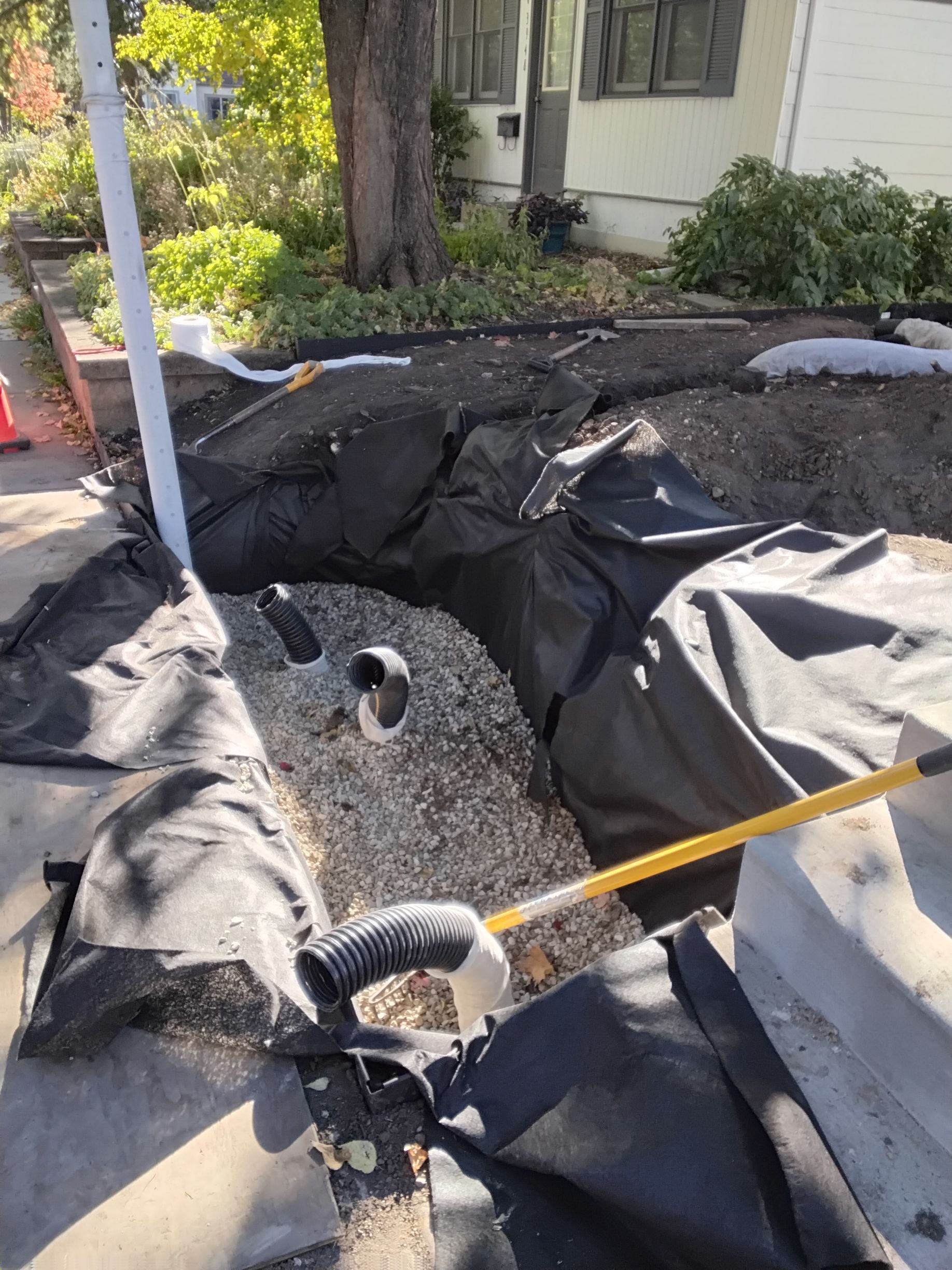 During: installed vertical water discharge pipes & filling the dry well with drainage rock