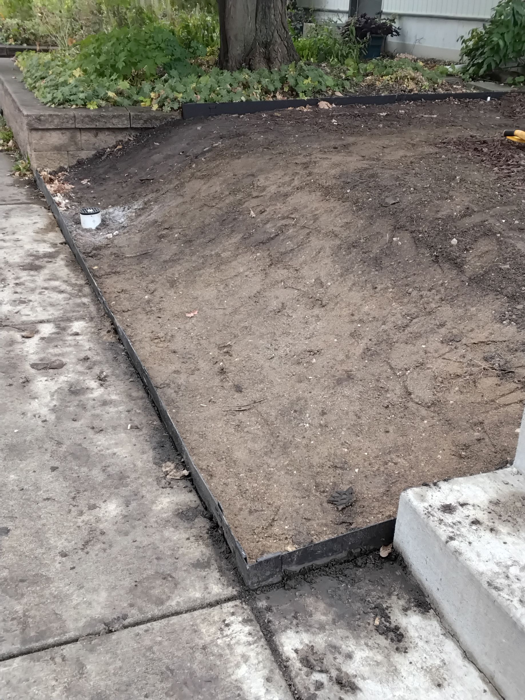 crew regraded soil to reinstall the slope we excavated to install the dry well and match the rest of the yard 